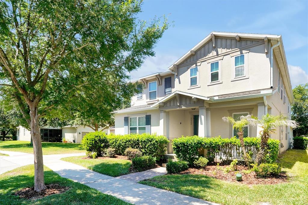 An aerial view shows a suburban neighborhood with houses surrounding a central pond — 7922 WINTER WREN STREET, WINTER GARDEN, FL