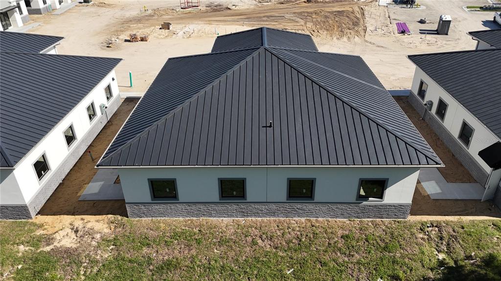 An aerial view of a modern building with a dark metal roof and stone siding — 80 EXCHANGE LOOP LOOP UNIT 2, PALM COAST, FL