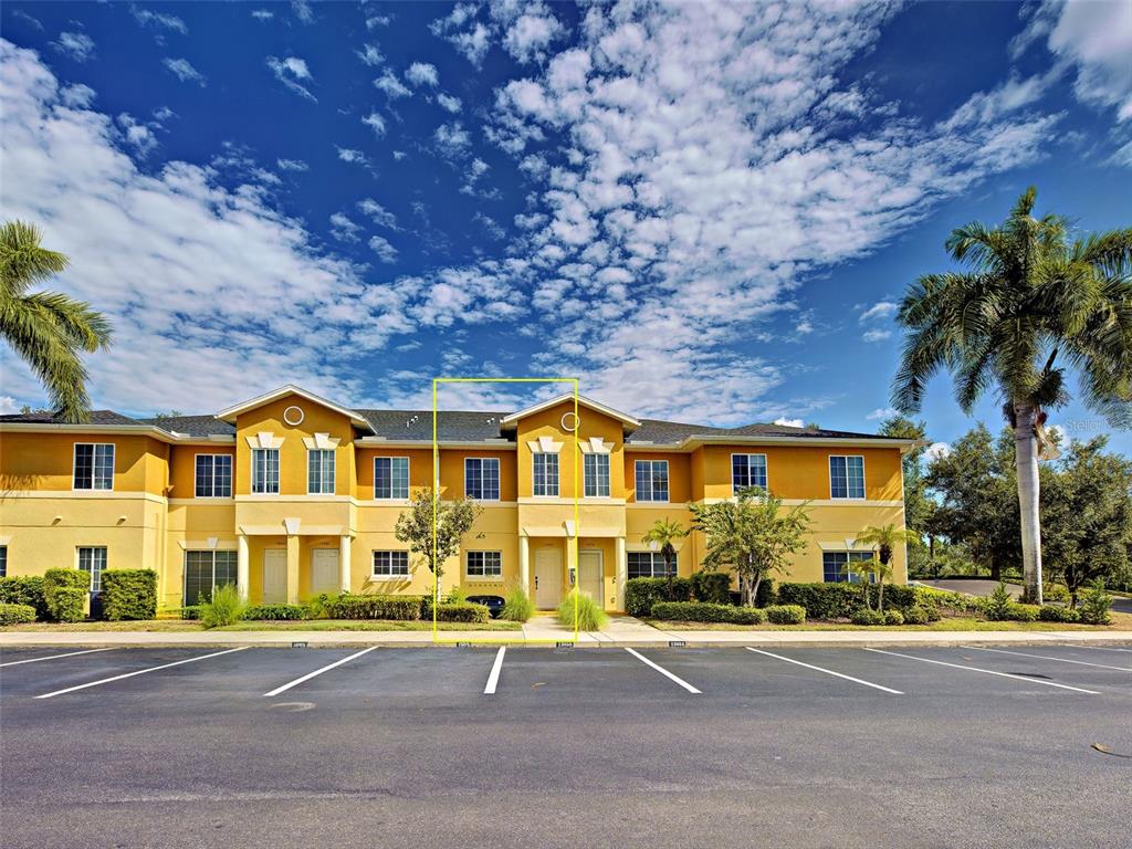 A yellow two-story apartment building with a parking lot in the foreground — 13050 TIGERS EYE DRIVE, VENICE, FL