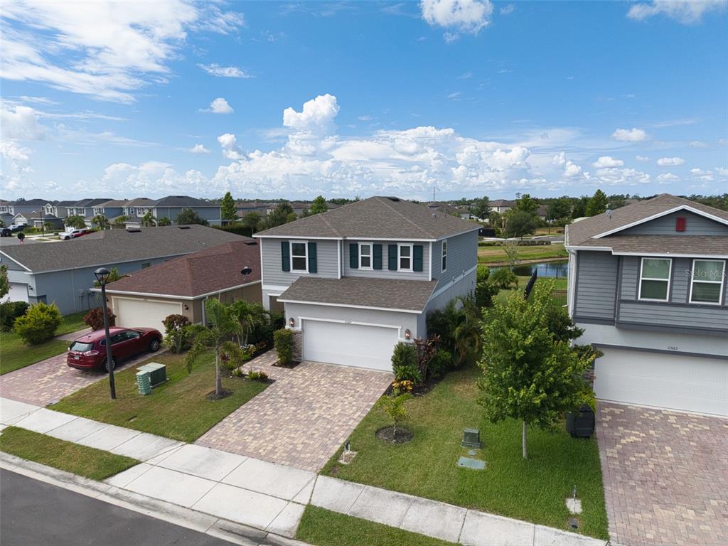 A backyard view of a two-story house with a patio, fire pit, and string lights — 11567 GALLATIN TRAIL, PARRISH, FL