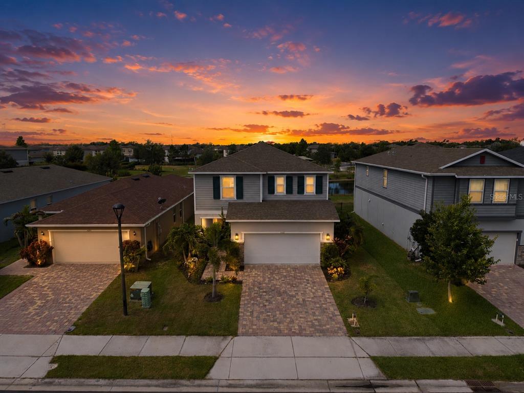 A brick walkway leads to a patio with chairs and a fire pit at sunset — 11567 GALLATIN TRAIL, PARRISH, FL