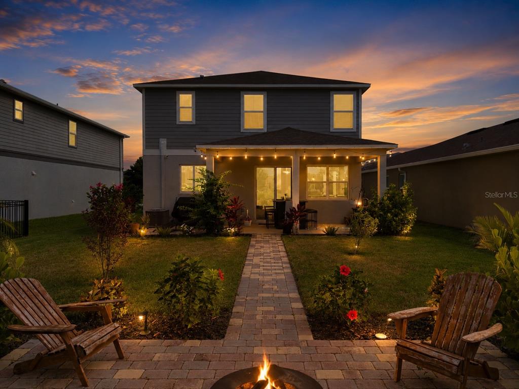 A covered patio features a bar set, outdoor lighting, and a view of a sunset — 11567 GALLATIN TRAIL, PARRISH, FL