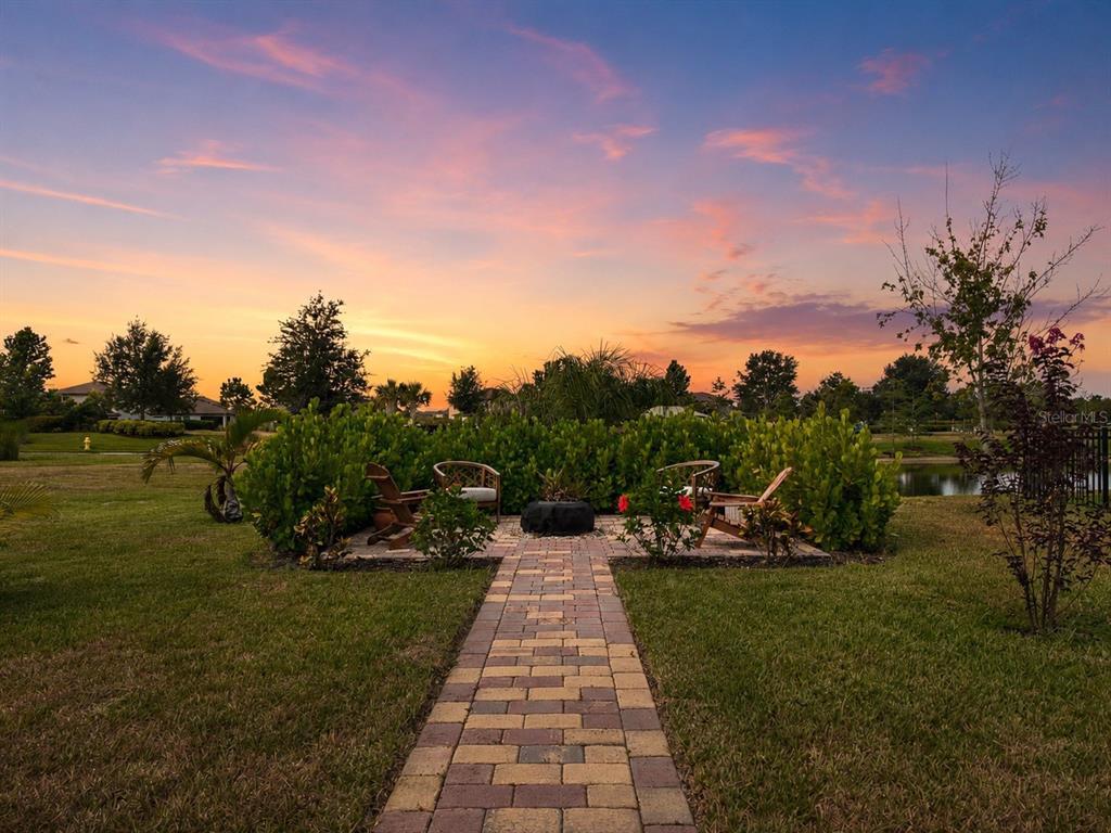 An aerial view of a two-story suburban house with a paved driveway at sunset — 11567 GALLATIN TRAIL, PARRISH, FL