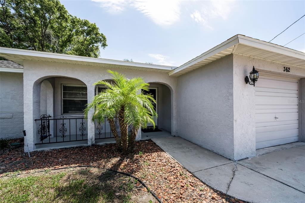 A single-story house with a palm tree in the front yard and a driveway — 362 PORTLAND AVENUE, SPRING HILL, FL