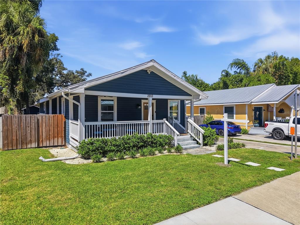 A blue house with a front porch and a white fence stands on a lawn — 2910 N OLA AVENUE, TAMPA, FL