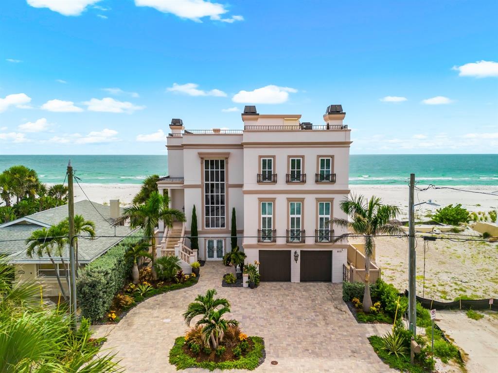 A three-story house with a paved driveway, two garage doors, and a palm tree — 810 ELDORADO AVENUE, CLEARWATER BEACH, FL