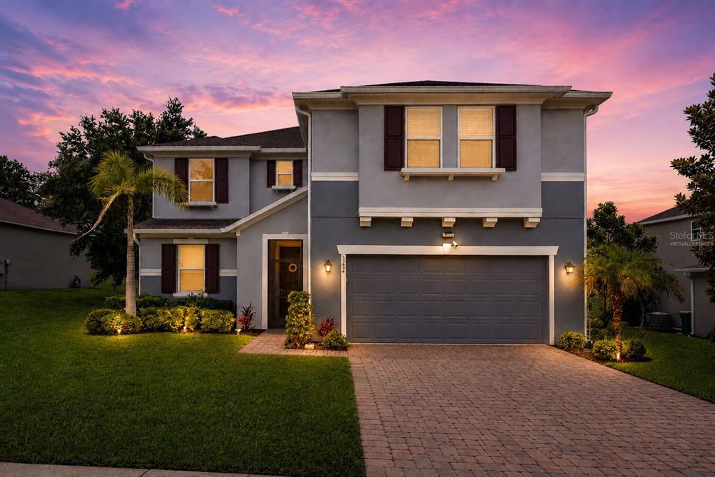 A two-story gray house with a paved driveway, a garage, and a landscaped front yard — 3254 LANDING VIEW, TAVARES, FL