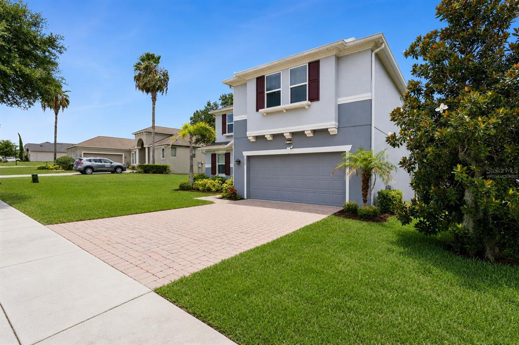 A two-story house with a gray exterior, a brick driveway, and a two-car garage — 3254 LANDING VIEW, TAVARES, FL