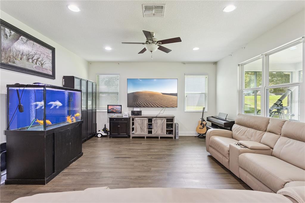 A living room features a large fish tank, a wall-mounted television, and a beige sofa — 3254 LANDING VIEW, TAVARES, FL