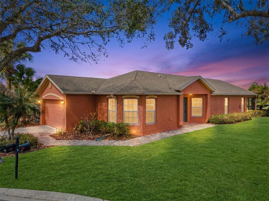An aerial view shows suburban houses with brown roofs surrounding a small, blue retention pond — 524 MURANO DRIVE, POINCIANA, FL