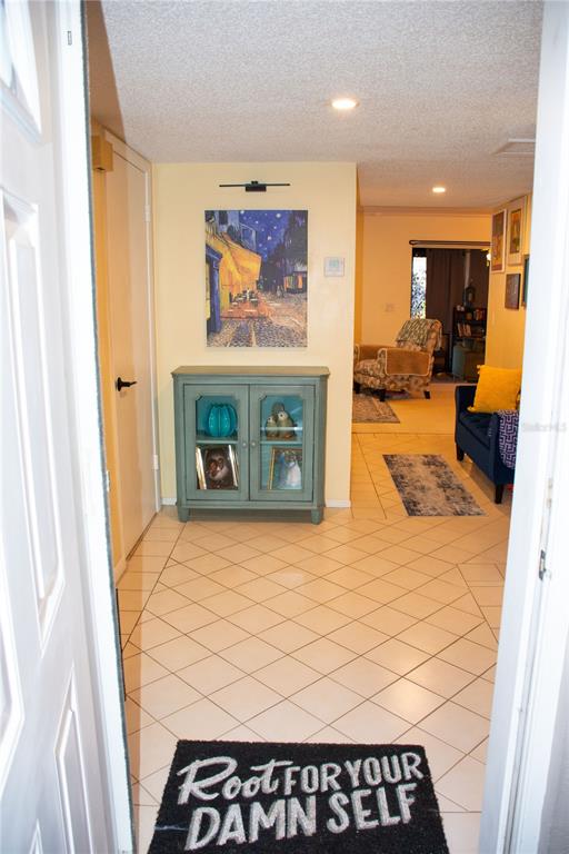 An entryway features a teal cabinet, a painting, and a doormat on tiled flooring — 155 FALLWOOD STREET, FERN PARK, FL