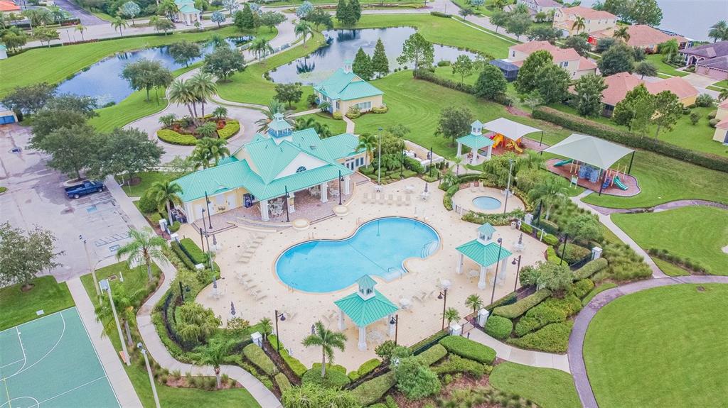 An aerial view shows a community clubhouse with a swimming pool, playground, and basketball court — 5108 BUTTERFLY SHELL DRIVE, APOLLO BEACH, FL