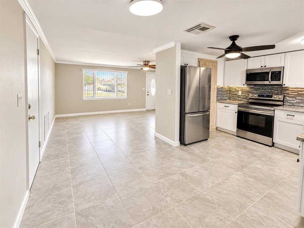 A bathroom features a gray vanity, a white toilet, and a shower with a curtain — 4033 NEWCASTLE DRIVE, NEW PORT RICHEY, FL