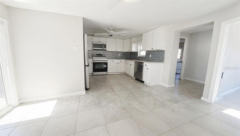 A bathroom features a white vanity, a tiled shower stall, and light-colored floor tiles — 4033 NEWCASTLE DRIVE, NEW PORT RICHEY, FL