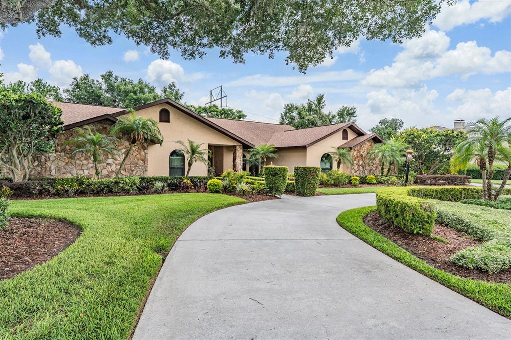 A single-story house with a stone facade and a curved concrete driveway — 13203 SPINDLEWYCK COVE, RIVERVIEW, FL
