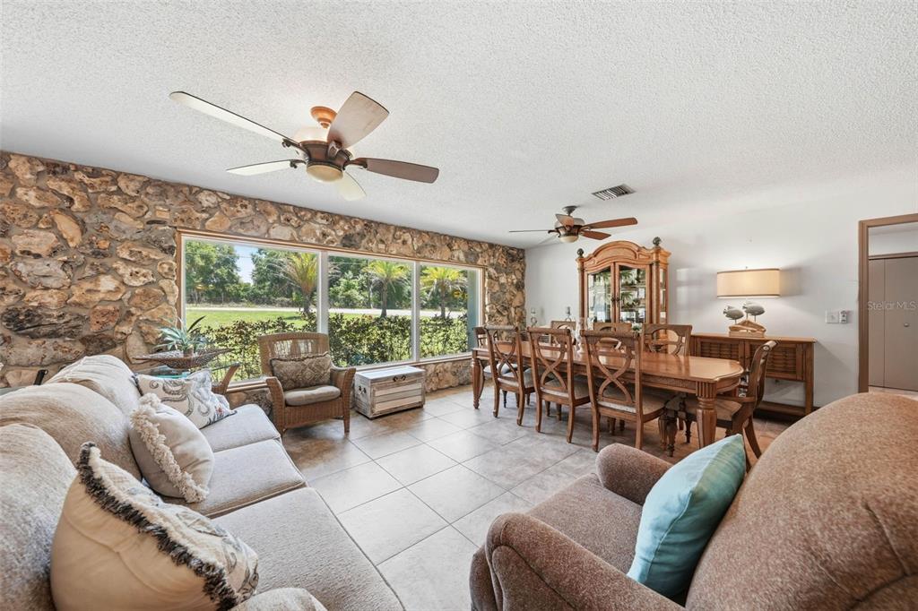 An open-concept dining room, kitchen, and living area with wood furniture and tile flooring — 37237 GRAYS AIRPORT ROAD, LADY LAKE, FL