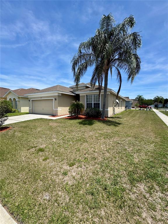 A single-story suburban house features a tan stucco exterior, a garage, and a palm tree — 1671 ISLEBROOK DRIVE, ORLANDO, FL