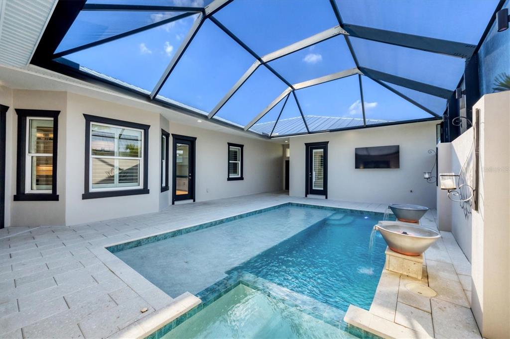 A swimming pool and spa are enclosed within a screened-in patio area — 8920 CONCH AVENUE, PLACIDA, FL