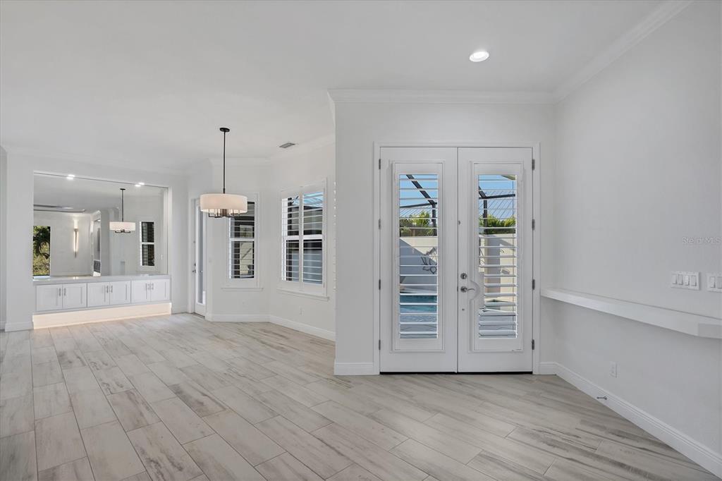 A bright room with light wood-look tile floors, white walls, and double glass-paneled entry doors — 8920 CONCH AVENUE, PLACIDA, FL