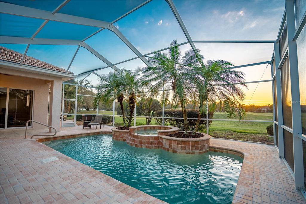 A single-story house with a paved driveway, tan stucco exterior, and two attached garages — 5021 CHAMPIONSHIP CUP LANE, SPRING HILL, FL