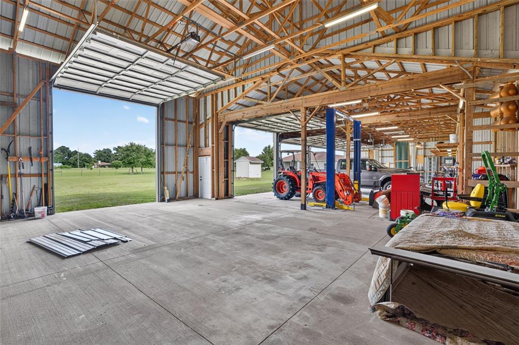 A living room features two gray sofas, a television on a stand, and a bicycle — 2440 CR 546, BUSHNELL, FL