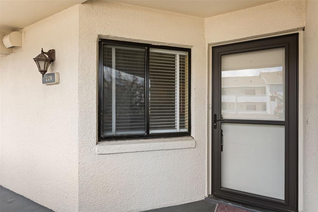 The exterior view shows a beige stucco wall with a window, a door, and a light — 4101 FAIRVIEW VISTA POINT UNIT 229, ORLANDO, FL