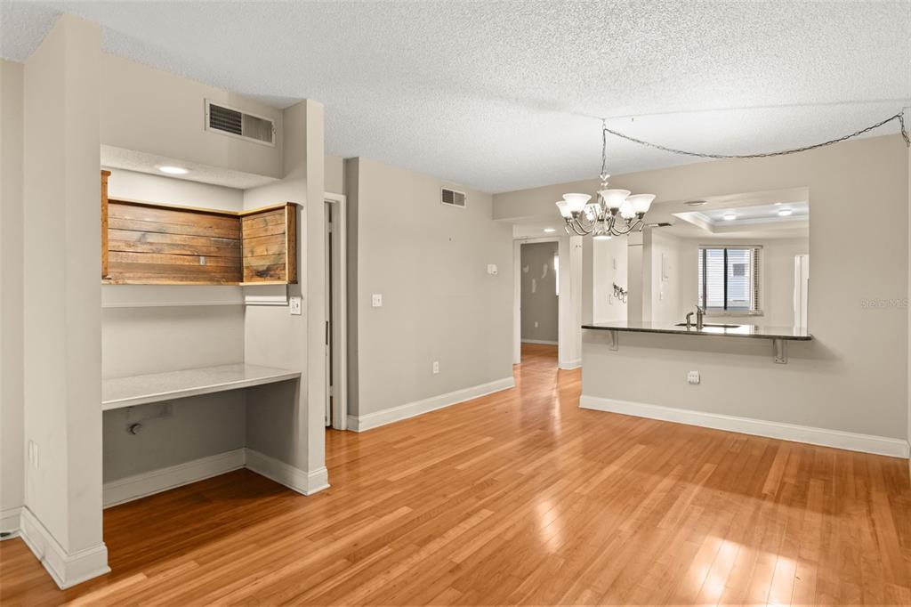 A dining area with hardwood floors, a breakfast bar, and a built-in desk nook — 4101 FAIRVIEW VISTA POINT UNIT 229, ORLANDO, FL