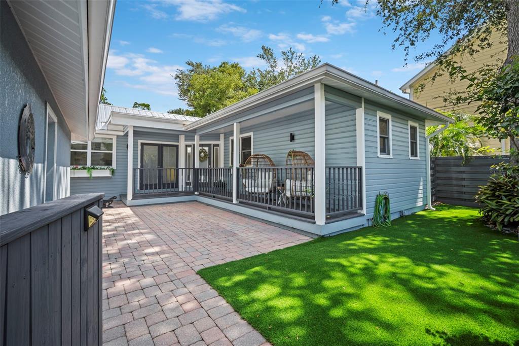 A blue house with a covered porch, brick patio, and artificial grass lawn — 1841 LAUREL STREET, SARASOTA, FL