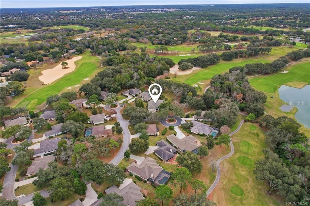 An aerial view shows a residential neighborhood situated among a golf course and trees — 3351 N HIDDEN VALLEY POINT, LECANTO, FL