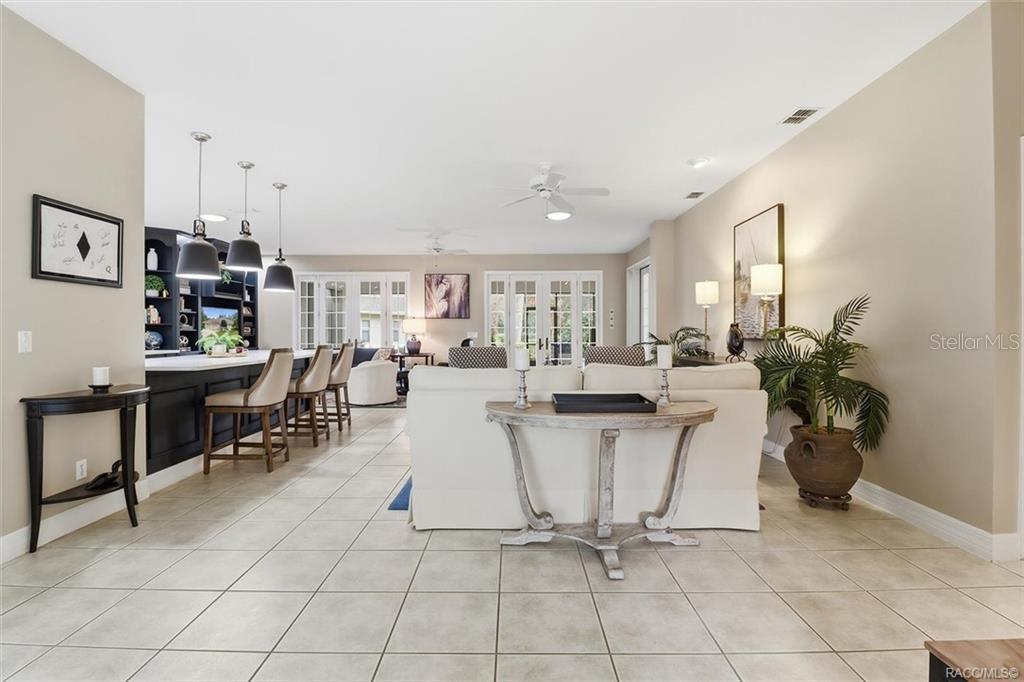 An open-concept living room and kitchen area featuring tile flooring and a white sofa — 3351 N HIDDEN VALLEY POINT, LECANTO, FL
