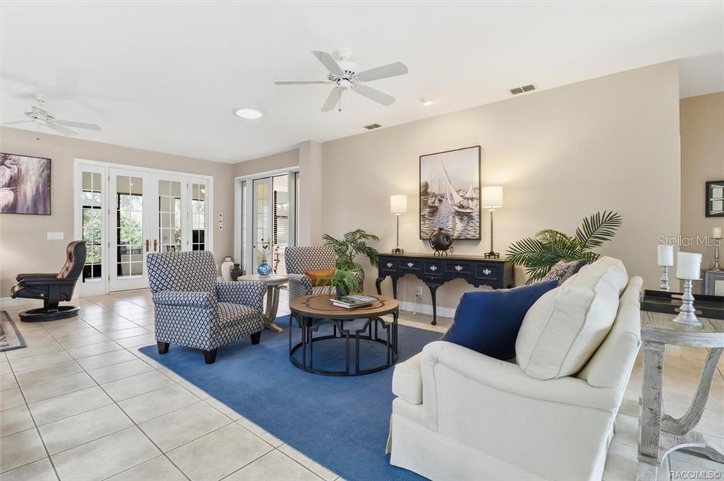 A living room features tile floors, a blue area rug, seating, and a ceiling fan — 3351 N HIDDEN VALLEY POINT, LECANTO, FL