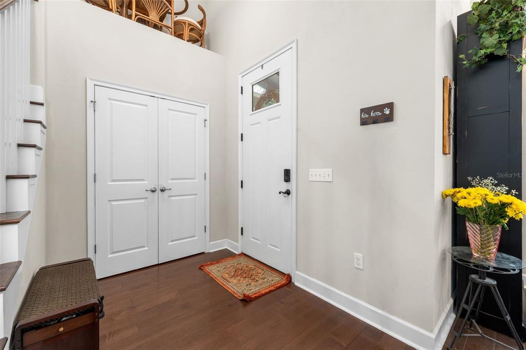 An entryway features hardwood floors, a white front door, double closet doors, and stairs — 8317 SW 78TH LANE, GAINESVILLE, FL