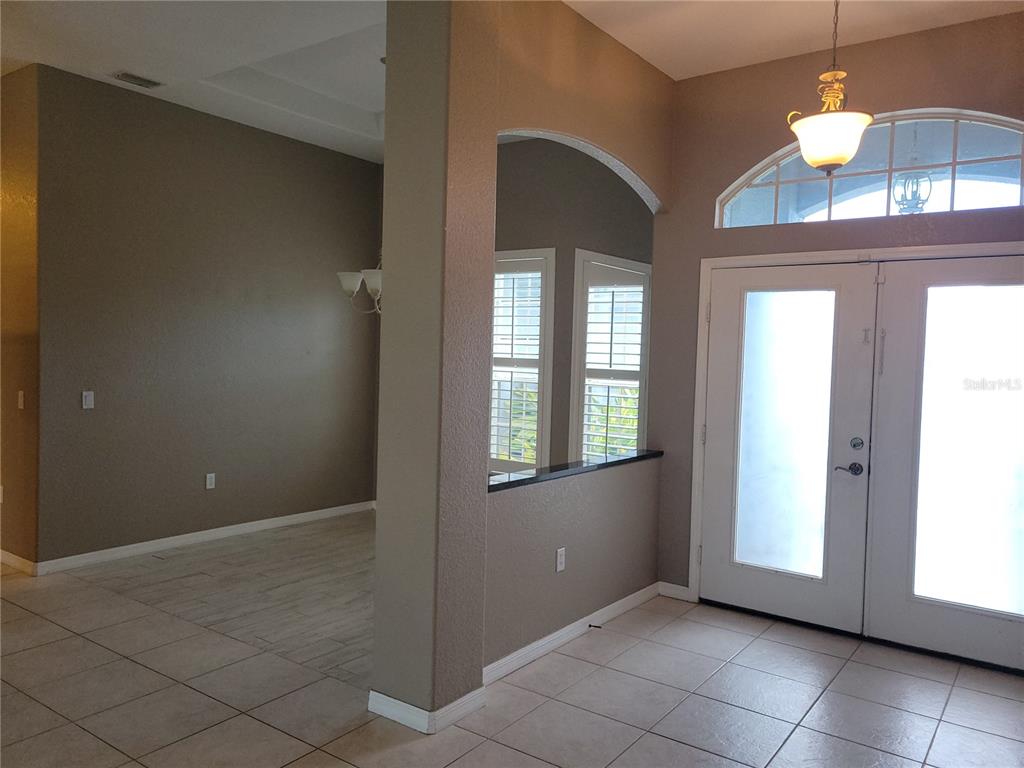 An entryway with tile flooring, a double front door, and an arched wall opening — 9 BUNKER TERRACE, ROTONDA WEST, FL