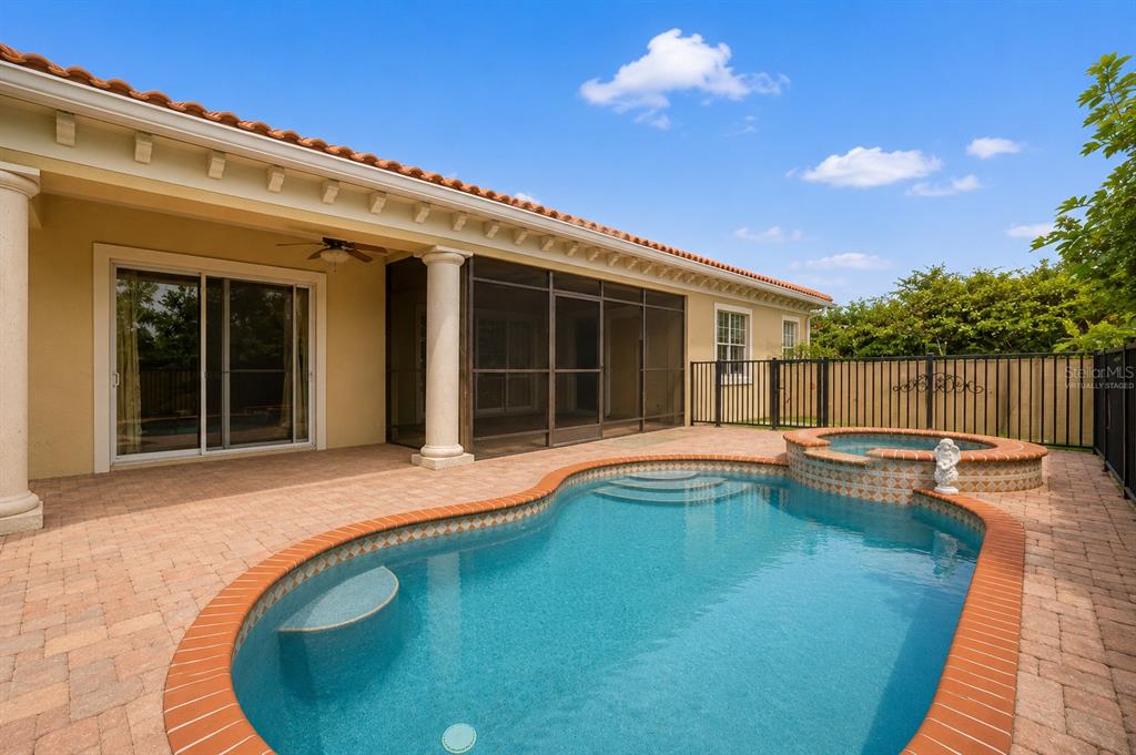 A backyard features a swimming pool, a hot tub, a lounge chair, and a fence — 20831 COPPERHEAD DRIVE, LEHIGH ACRES, FL