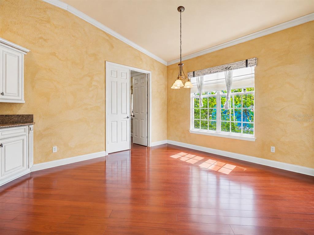 A spacious living room features a coffered ceiling, hardwood floors, and a large leather sectional — 20831 COPPERHEAD DRIVE, LEHIGH ACRES, FL