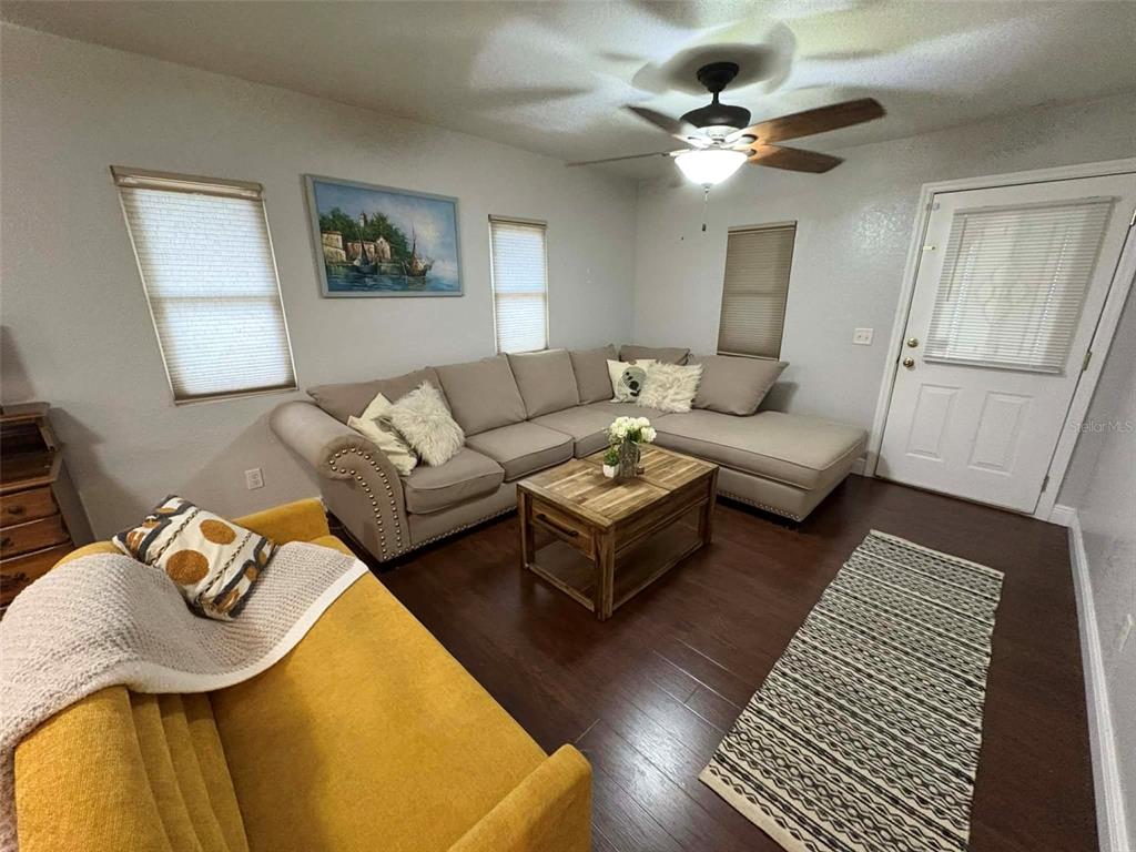A living room features a large sectional sofa, a yellow couch, and a wooden coffee table — 1040 S OHIO AVE, LAKELAND, FL