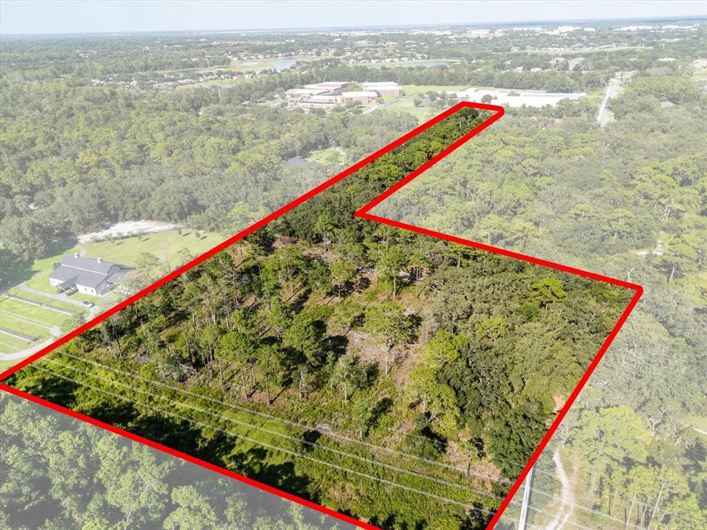 An aerial view shows a wooded plot of land outlined in red — MARKHAM WOODS ROAD, LAKE MARY, FL