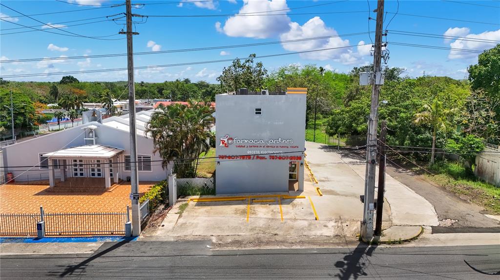 An aerial view shows a pharmacy building next to a church with a parking lot — 16 GUARICO AVENUE, VEGA BAJA, PR