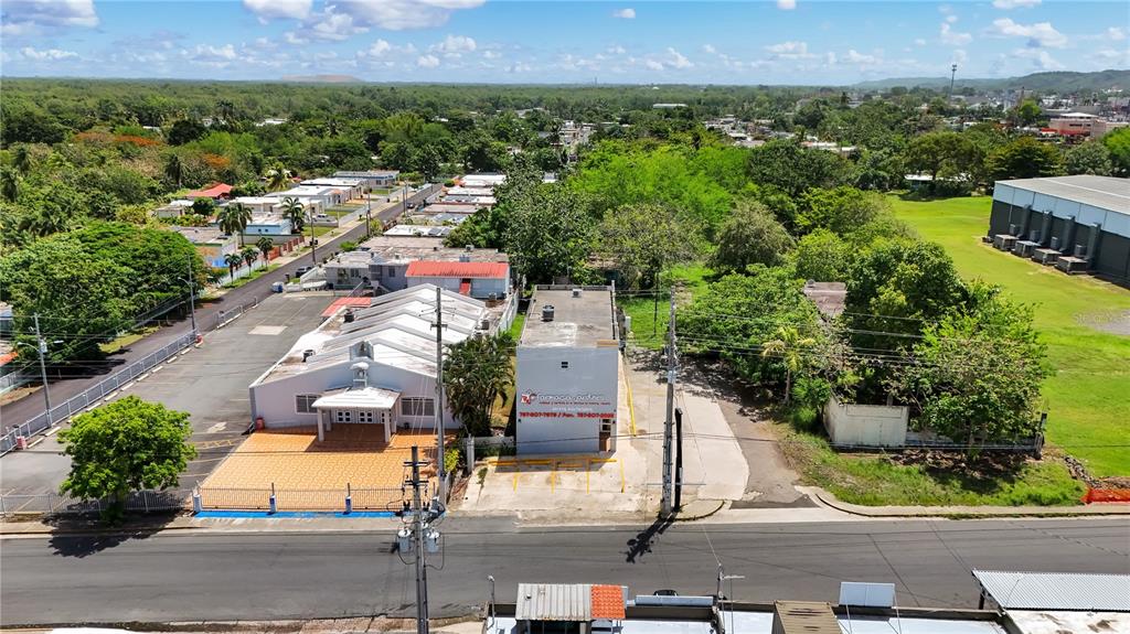 An aerial view shows a commercial building and an adjacent church with parking lots — 16 GUARICO AVENUE, VEGA BAJA, PR