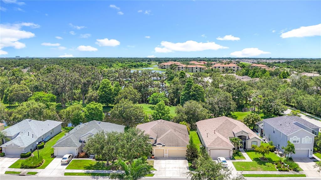 An aerial view shows a row of suburban houses with driveways facing a street and trees — 3409 61ST TERRACE E, ELLENTON, FL