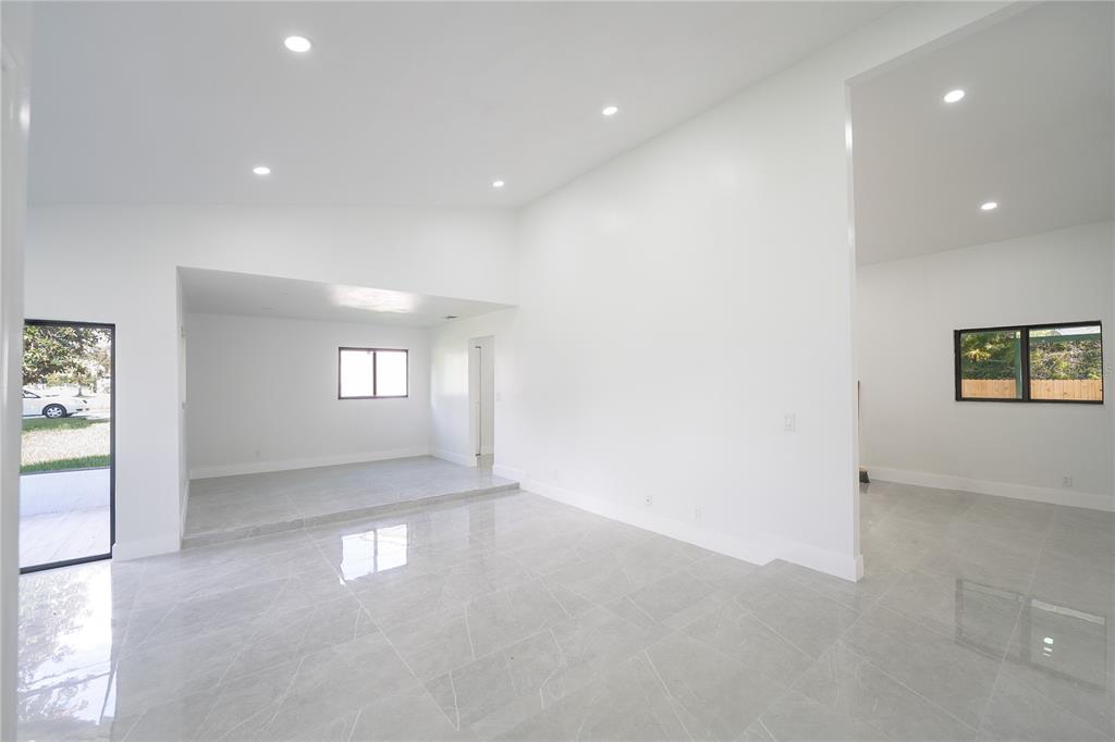 A bright, open-concept living area features white walls, recessed lighting, and light gray tiled floors — 848 E FLAG LANE, KISSIMMEE, FL