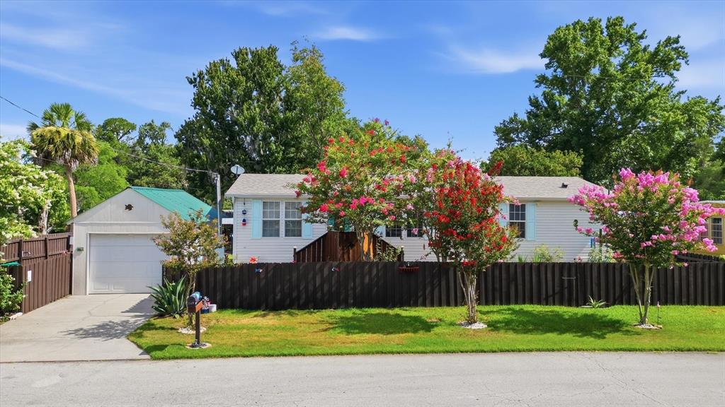 A single-story house with light siding, a detached garage, and blooming crepe myrtle trees — 8421 W SCOTT COURT, HOMOSASSA, FL