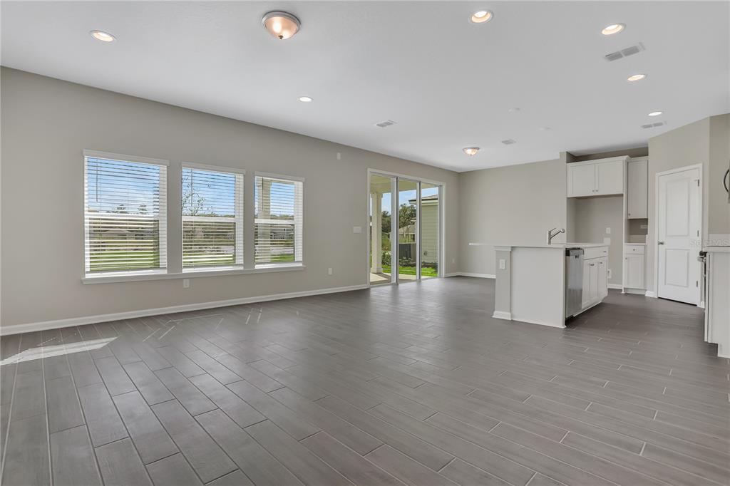 An open-concept living area features gray tile flooring, recessed lighting, and a kitchen island — 377 BROOK FOREST DRIVE, ST AUGUSTINE, FL