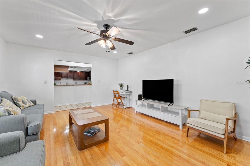 A living room features hardwood floors, a ceiling fan, a television console, and a sofa — 4614 W FIG STREET UNIT B, TAMPA, FL