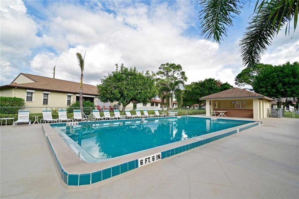 A rectangular swimming pool with a depth marker sits on a concrete patio outdoors — 3112 VIVIENDA BOULEVARD, BRADENTON, FL