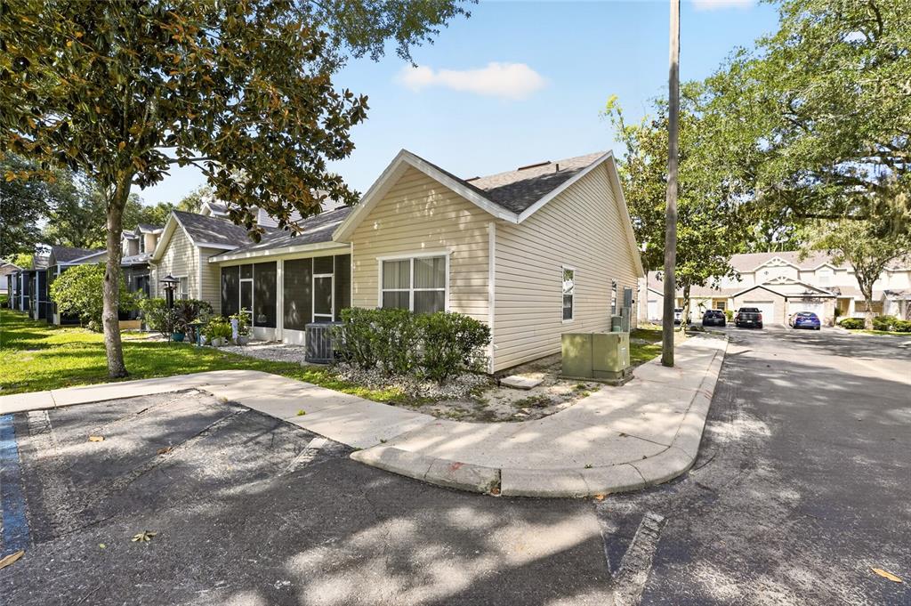 A concrete walkway leads to the recessed front entrance of a house with beige siding — 4700 SW ARCHER ROAD UNIT S-127, GAINESVILLE, FL