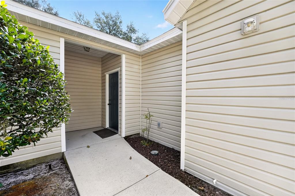 An entryway features a white built-in mudroom bench with coat hooks and overhead storage cubbies — 4700 SW ARCHER ROAD UNIT S-127, GAINESVILLE, FL