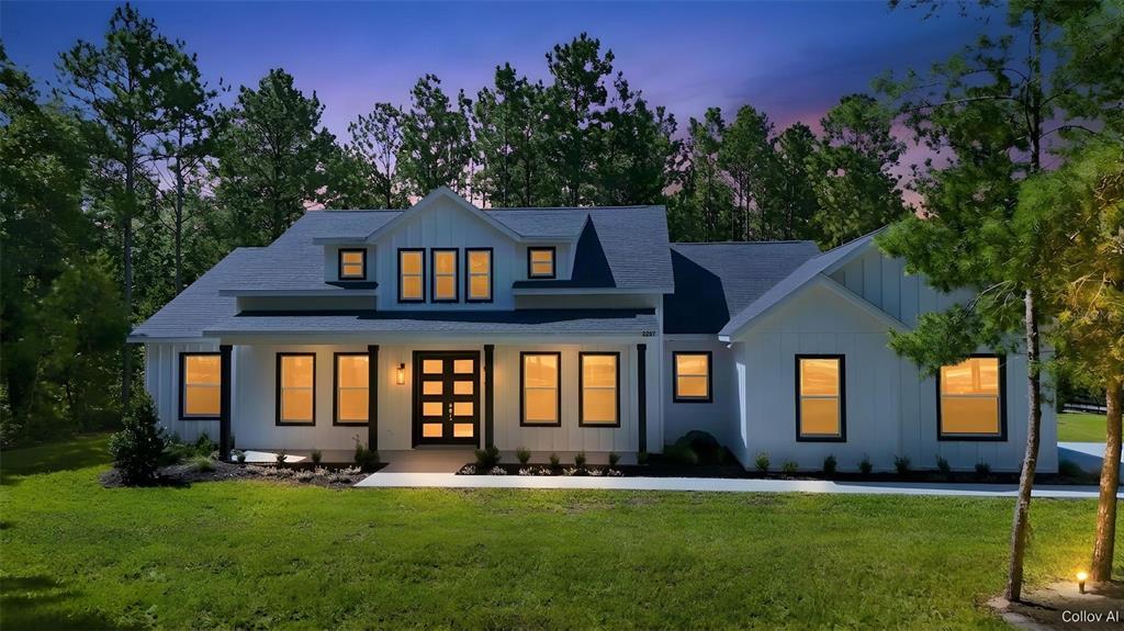 A covered porch features white board-and-batten siding, black window frames, and a dark front door — 2207 COUNTY ROAD 243E, WILDWOOD, FL
