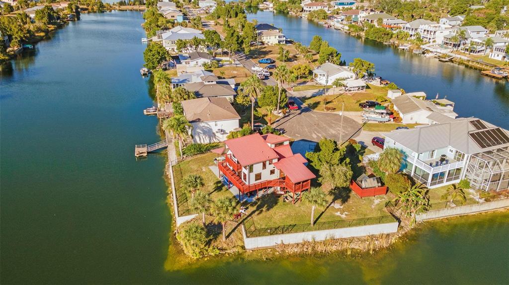An aerial view of a waterfront house with a red roof on a canal lot — 3179 AZALEA DRIVE, HERNANDO BEACH, FL