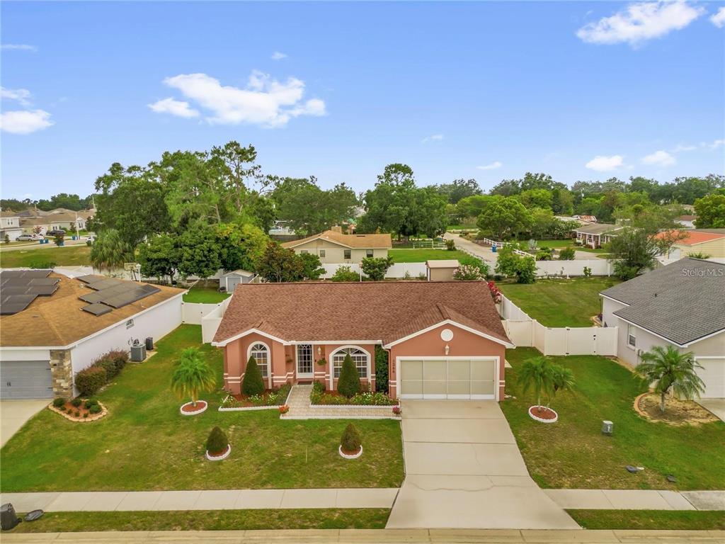 An aerial view of a single-story house with a terracotta exterior and a two-car garage — 1366 MERRIMACK PLACE, DAVENPORT, FL